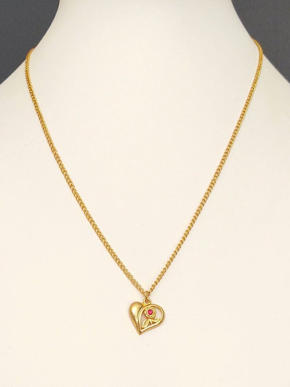 Gold heart pendant necklace with flower and faux ruby detail